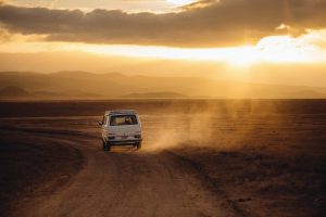Volkswagen campervan traveling a dusty road