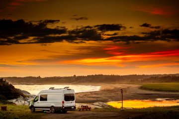 white van on snow covered ground during sunset