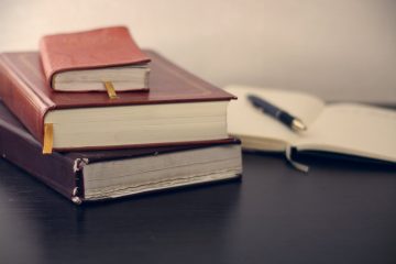 forecasting Concentration selective focus photography of three books beside opened notebook