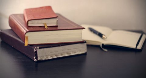 books forecasting Concentration selective focus photography of three books beside opened notebook