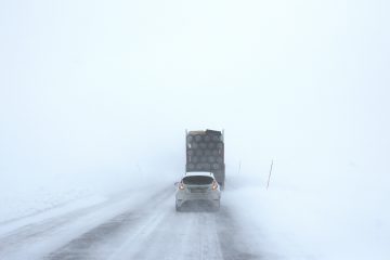 truck accidents white car behind a truck on snowy road