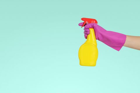 Attention person holding yellow plastic spray bottle