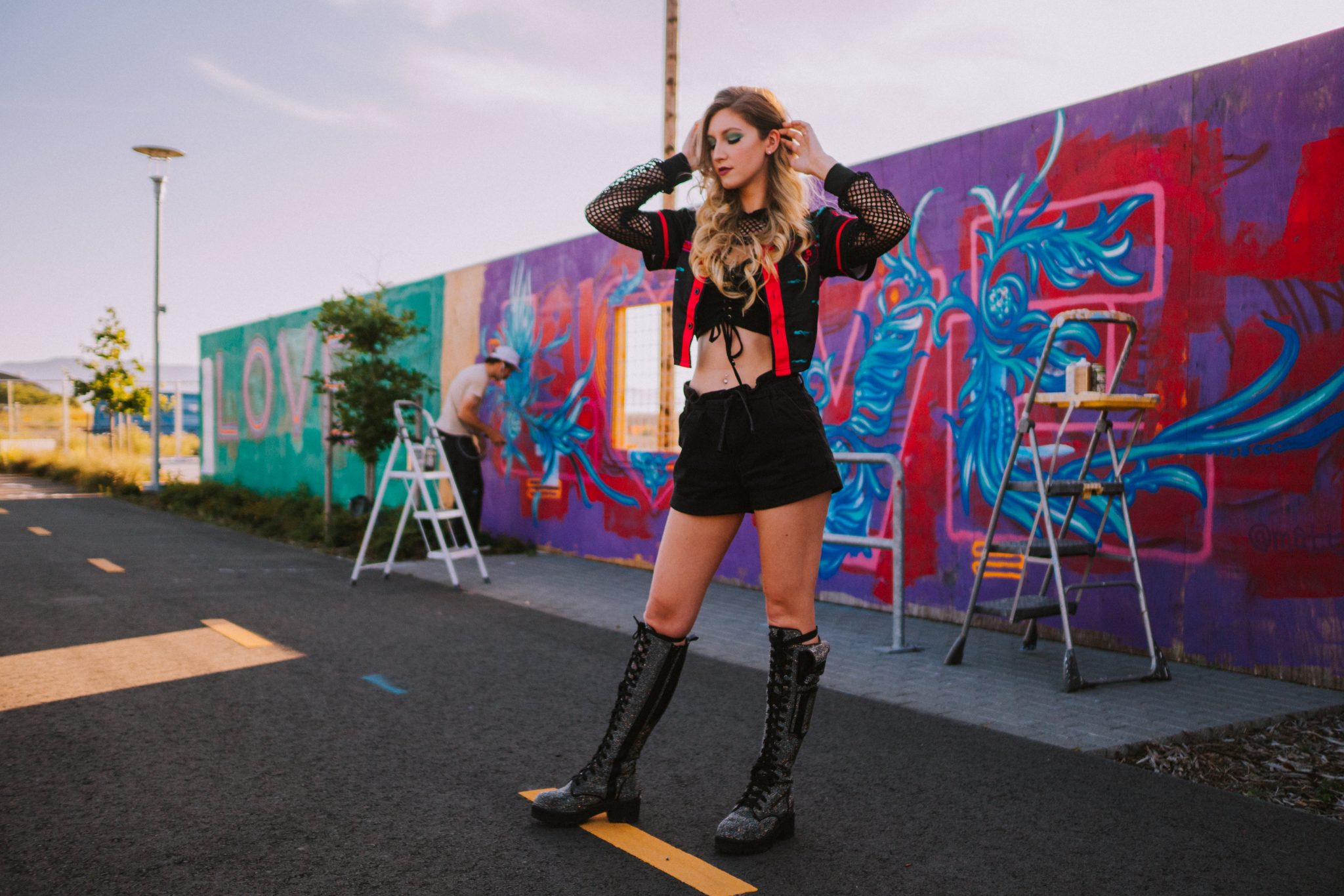 photo influencer marking Platform Boots woman in black jacket and blue denim jeans standing on black asphalt road during daytime