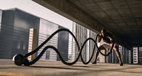 Fitness Journey woman in black tank top sitting on brown wooden bench