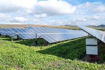 Eco-Friendly Greener Lifestyle blue solar panels on green grass field under white clouds and blue sky during daytime