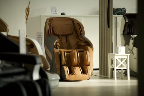 Massage Chair brown and black leather backpack on white wooden table