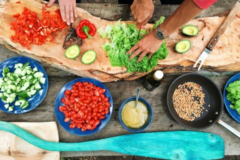 nutritionist cooking Food Groups Eating Habits Outdoor Kitchen person slicing green vegetable in front of round ceramic plates with assorted sliced vegetables during daytime