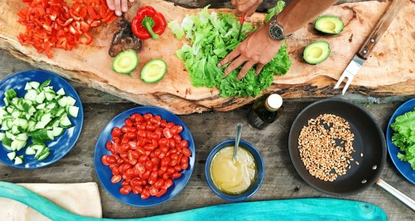 Cuisine catering Dinner Party nutritionist cooking Food Groups Eating Habits Outdoor Kitchen person slicing green vegetable in front of round ceramic plates with assorted sliced vegetables during daytime