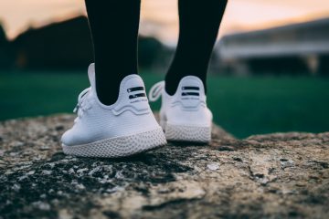 Compression Socks selective focus photography of person wearing shoes standing on rock