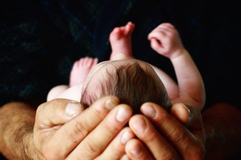 newborn person holding babys hand