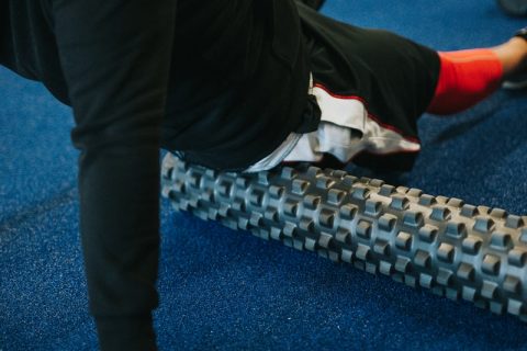 Foam rollers person in black pants and white shirt