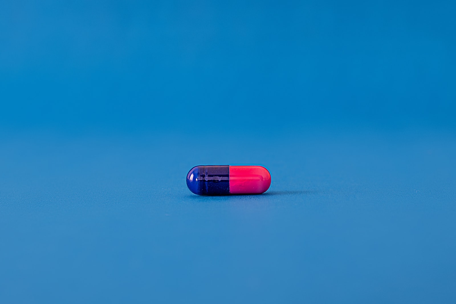 Drug Addiction Autism Supplements red and blue pill on blue surface