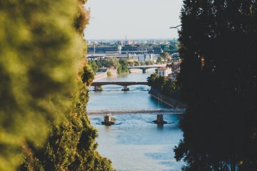 Near A River gray concrete bridge in between city buildings