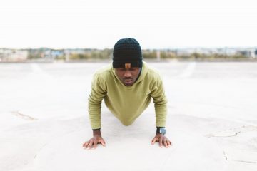 home gym Low Testosterone Home Workout man in green long-sleeved shirt doing a push-up on gray concrete pavement