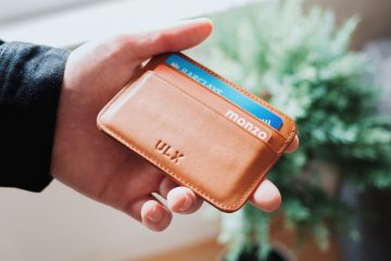 person holding brown ULX leather wallet
