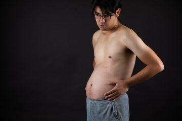 Gut Health topless man in blue denim jeans