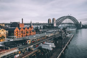 Australian Winter aerial photography of concrete buildings and bridge beside ocean under cloudy sky