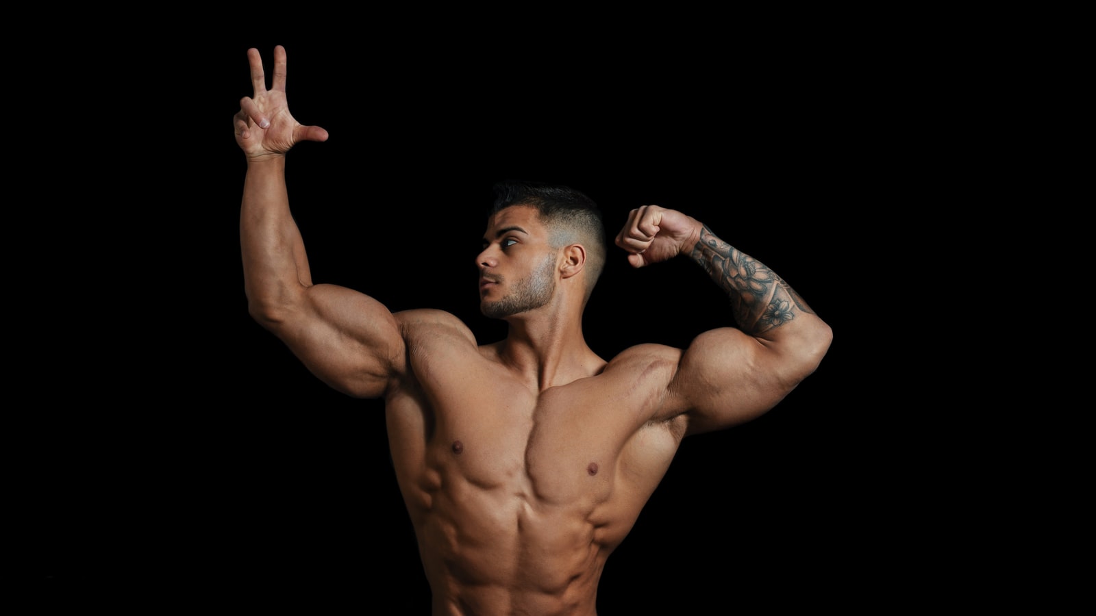 Shredded topless man with hands up
