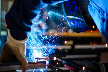 welding man holding gray steel frame