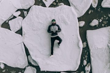Recovering stressful travel adventure back pain Antarctica man lying on iceberg during daytime