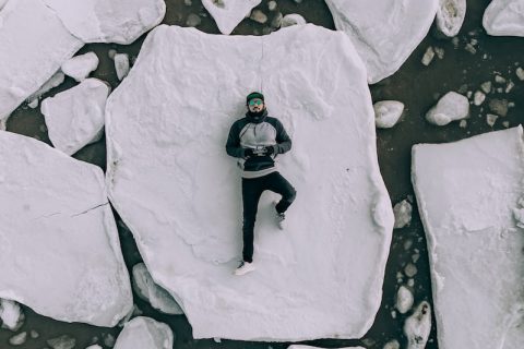 travel adventure back pain Antarctica man lying on iceberg during daytime