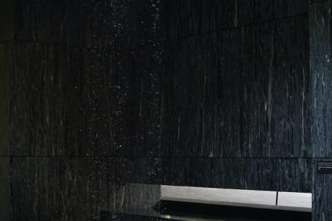shower gel black wooden bench beside black concrete wall