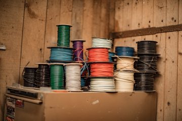 Home Repairs Twisted Pair Cables blue and green thread on brown wooden shelf