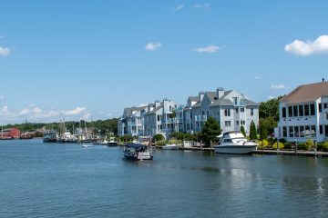 Connecticut white and black boat on sea near city buildings under blue sky during daytime