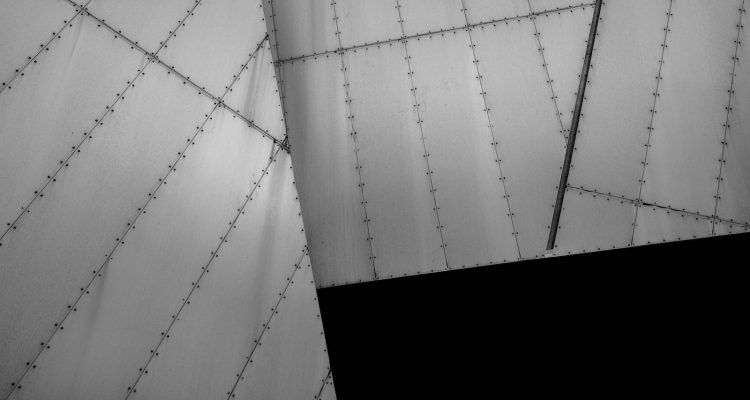 Manufacturers metal processing Sheet metal Black and white shot of bolted metal architecture lying at angles