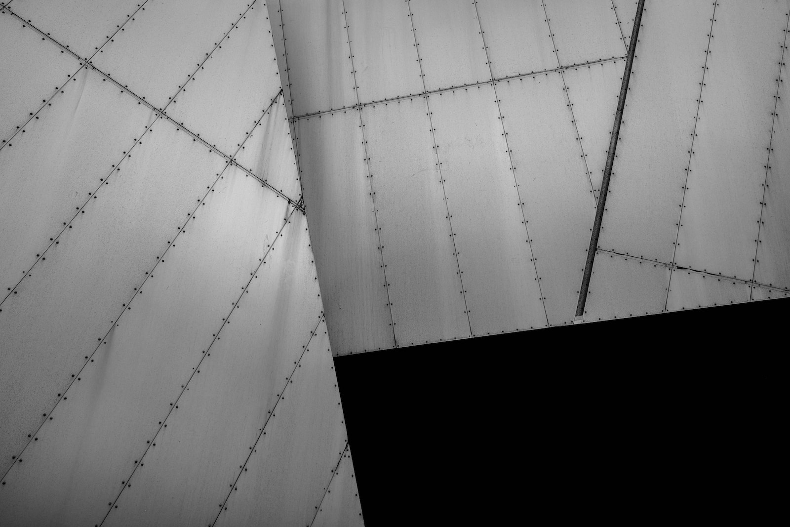Sheet metal Black and white shot of bolted metal architecture lying at angles