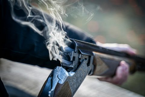 shotgun black semi automatic pistol with white smoke
