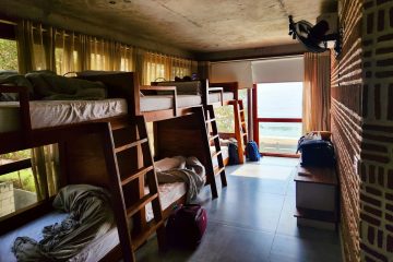 a room filled with lots of bunk beds next to a window