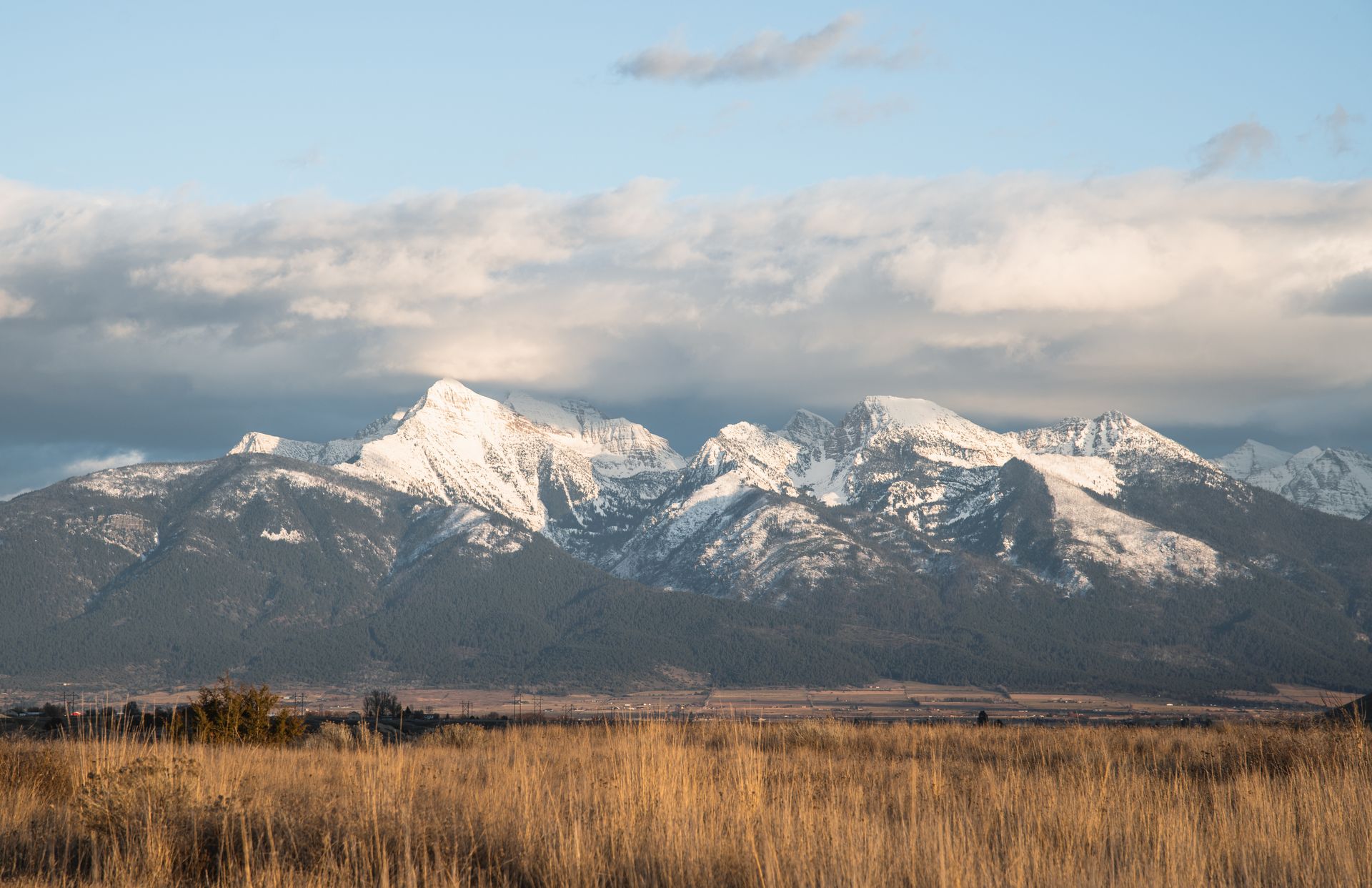 Snow-capped mountain range under a cloudy sky in Montana