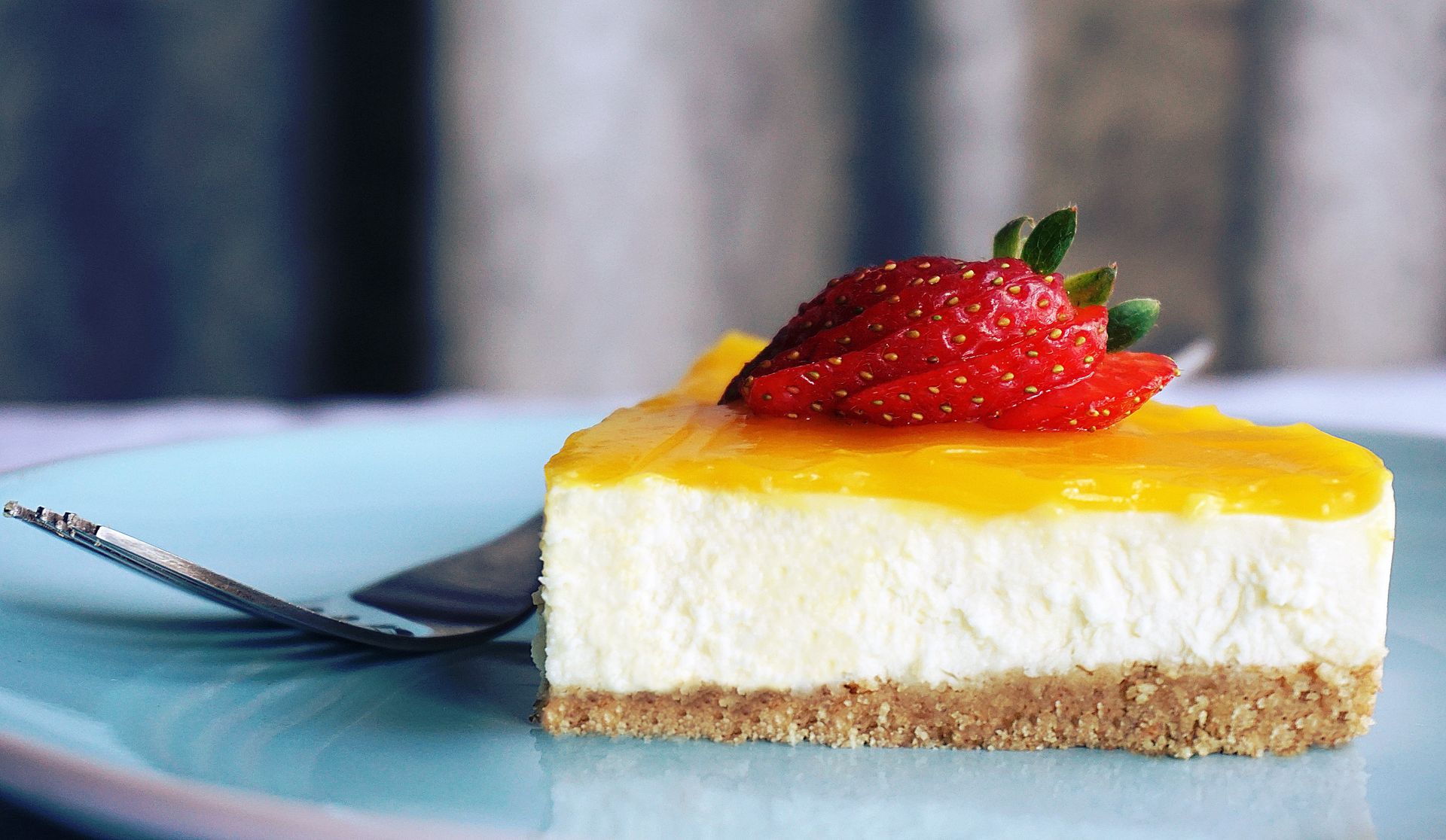 Close-up of a creamy dessert slice topped with fresh strawberries