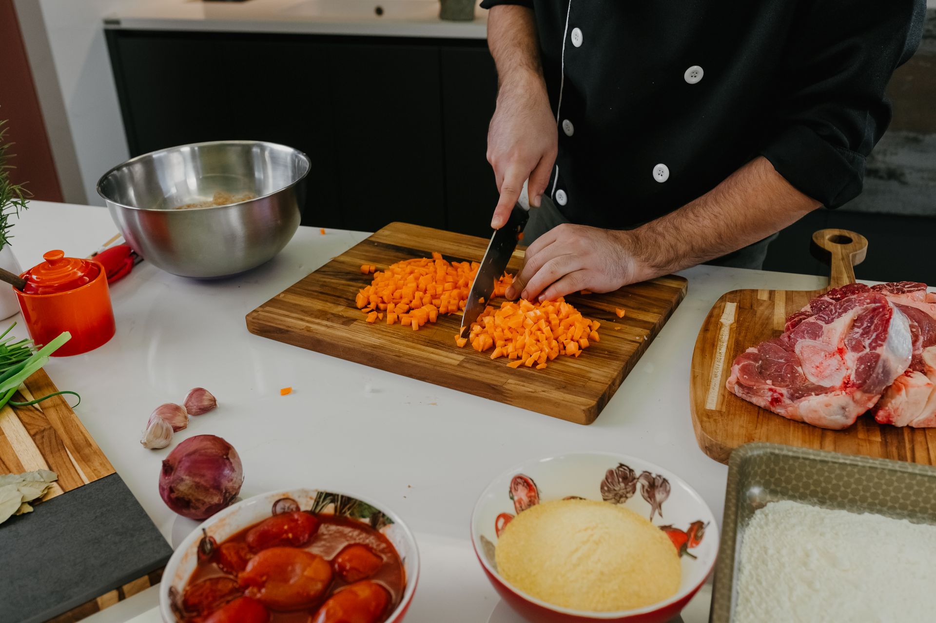 Chef chopping carrots and fresh ingredients on a cutting board