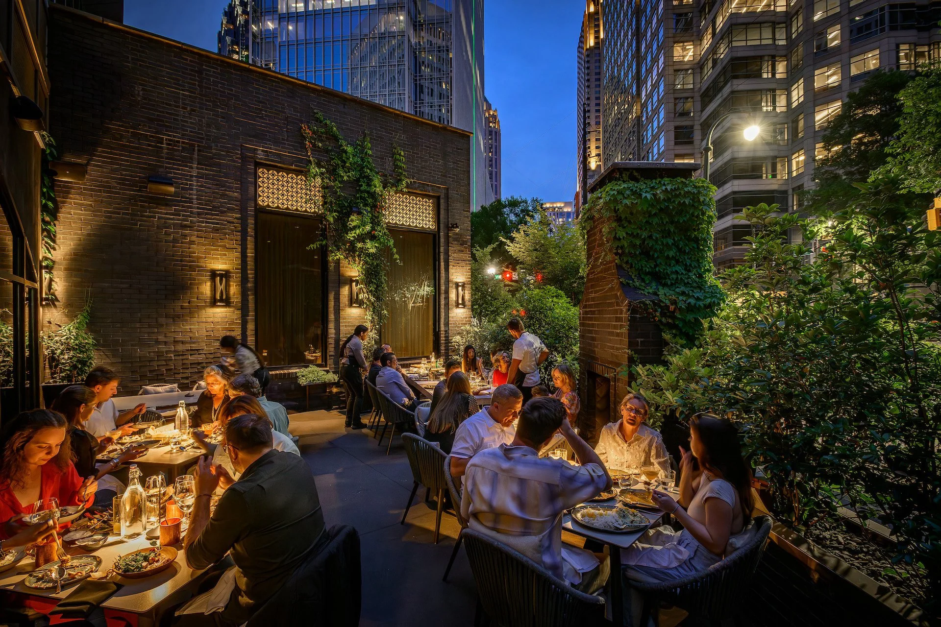 Outdoor restaurant patio at dusk with diners at Rumi's Kitchen