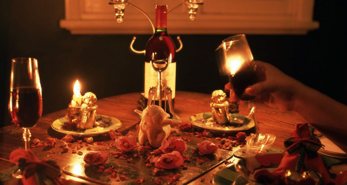 Candlelit dinner table set with wine glasses for a romantic date night