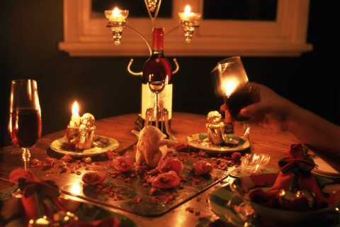 Candlelit dinner table set with wine glasses for a romantic date night