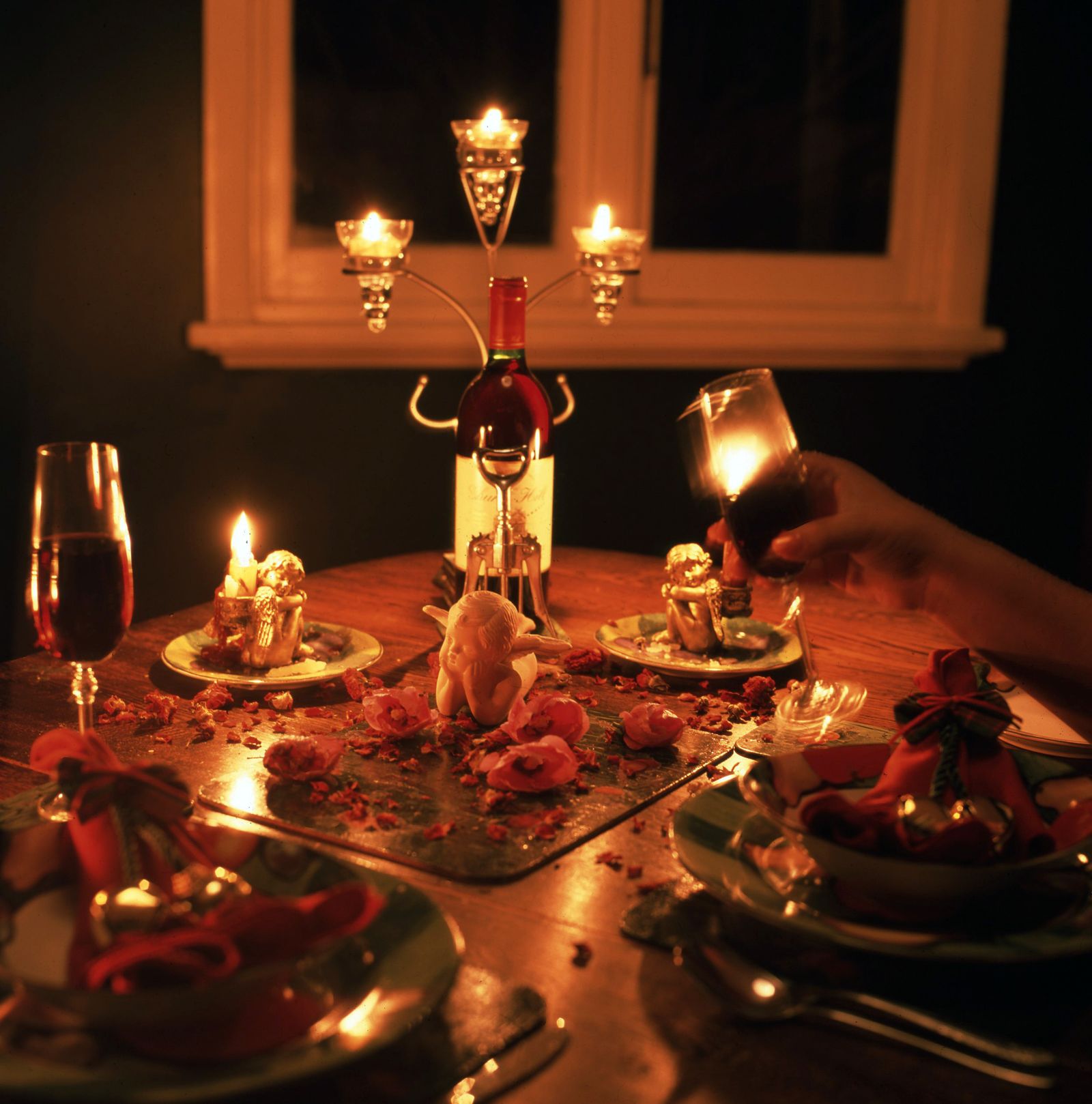Candlelit dinner table set with wine glasses for a romantic date night